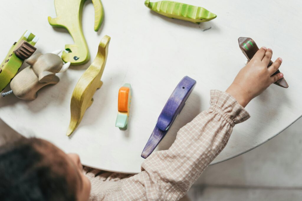 pexels-photo-3662669-3662669 Child playing with colorful wooden toys in a playful indoor setting.